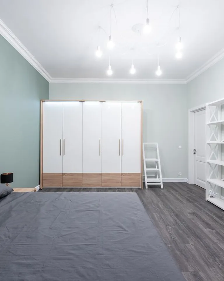 Tall white open shelf beside a dresser in a bedroom