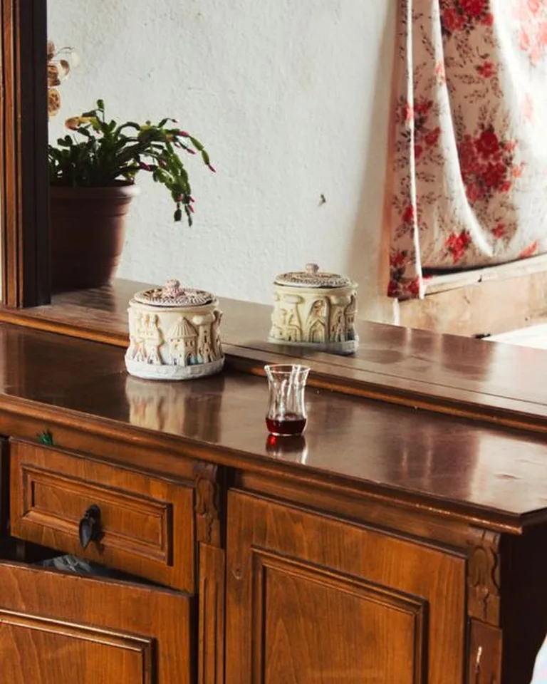 Ceramic lidded containers arranged on a wooden dresser top