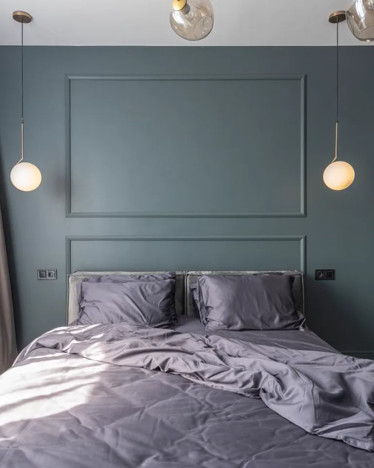 Modern bedroom with a dark accent wall and pendant lights