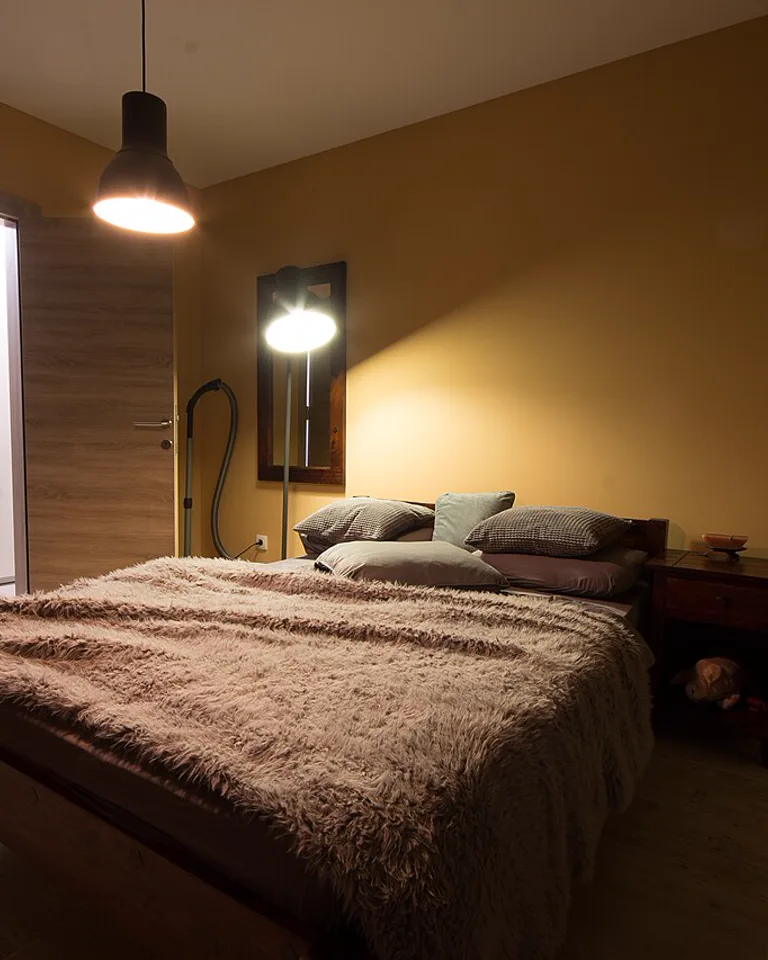 Warmly lit cozy bedroom with lamps at night
