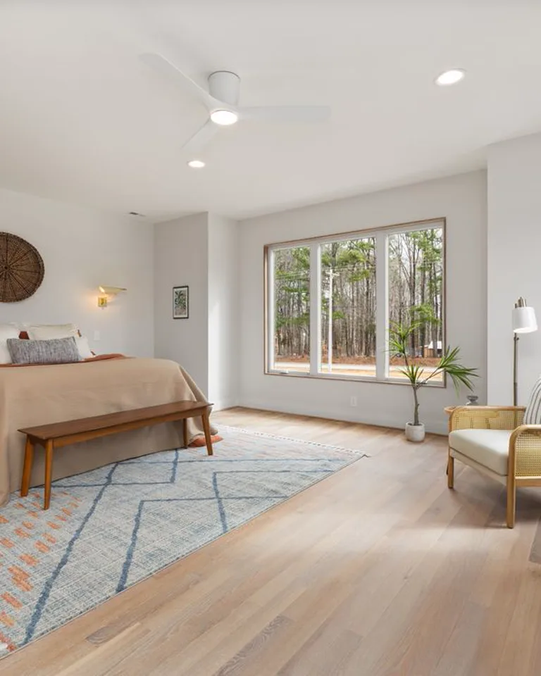 Spacious bedroom divided into sleeping and sitting zones with a large rug