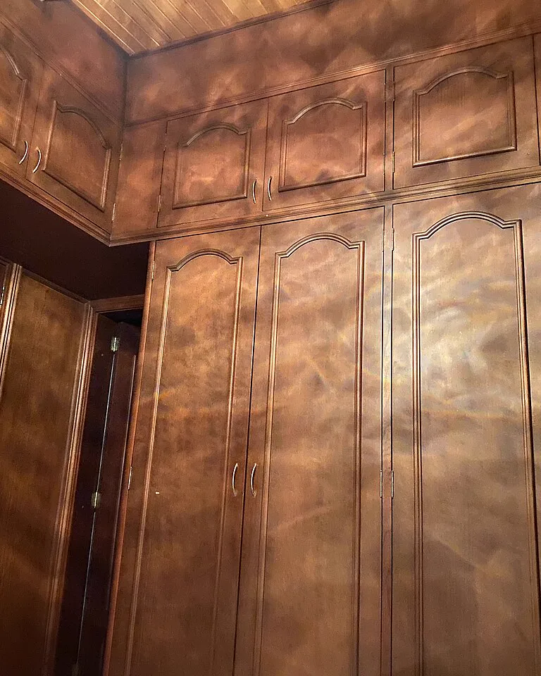 Built-in wardrobes wrapping around an angled bedroom corner