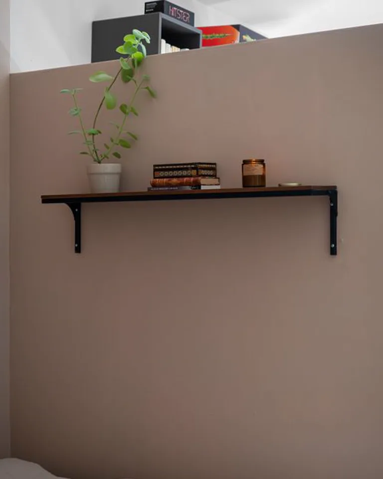 Bedroom wall shelves stepping down beside a bed
