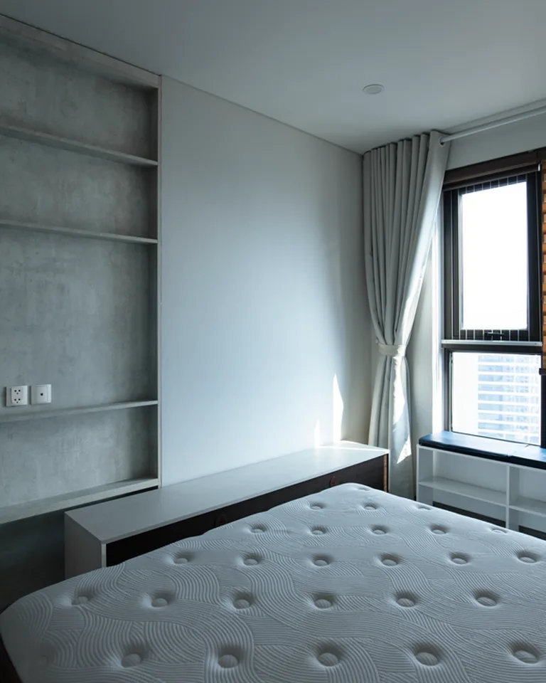 Built-in bedroom shelving fitted into an alcove beside a wall projection