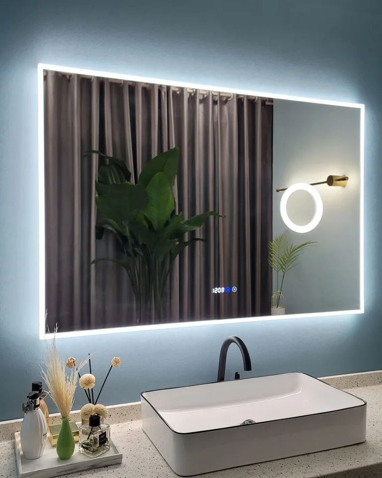 Backlit LED bathroom mirror glowing above a vessel sink
