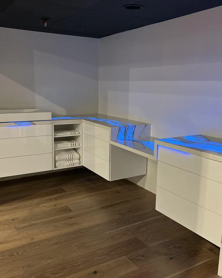 Floating blue vanity with LED strip glowing underneath the cabinet