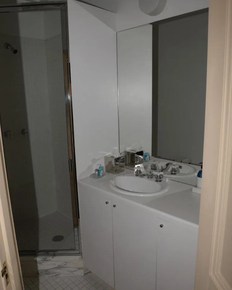 Modern white bathroom with layered vanity and ceiling lighting