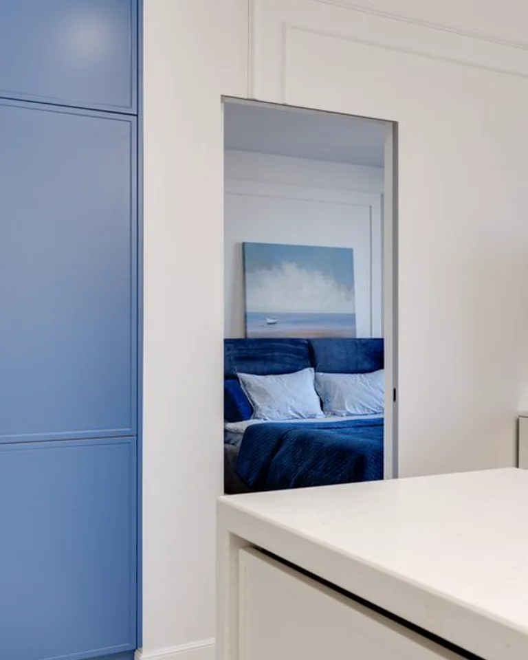 Bed seen through a bedroom doorway from the entrance