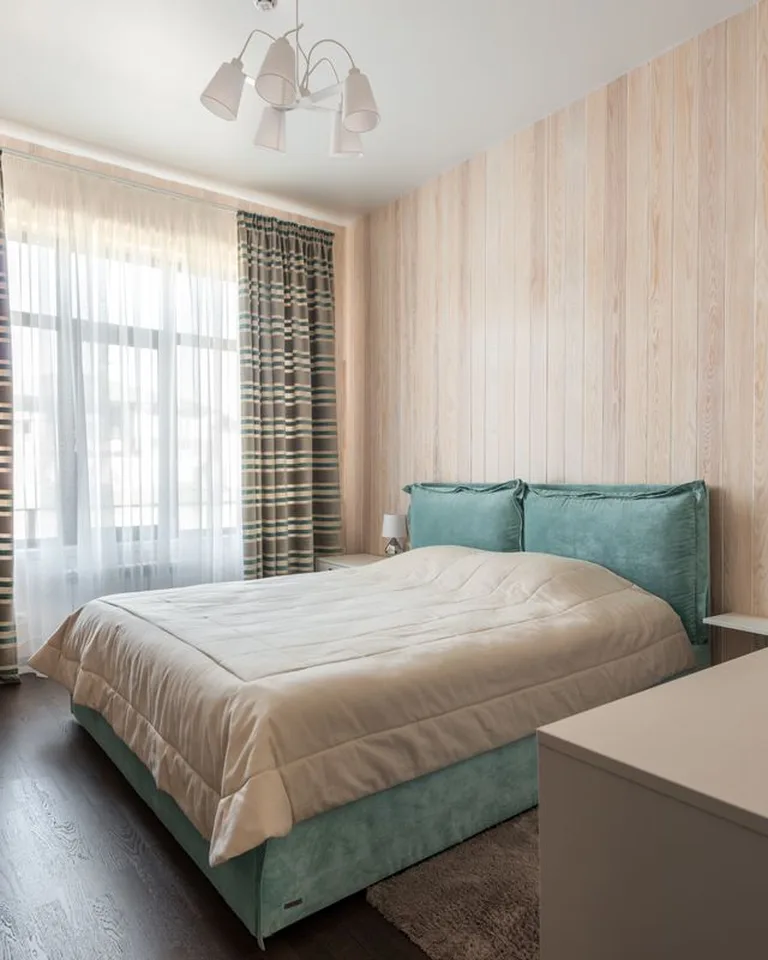 Bedroom with curtains hung high above the window to make the ceiling feel taller