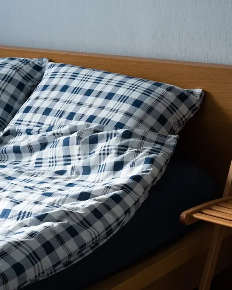 Black and white checkered rug beside a bed