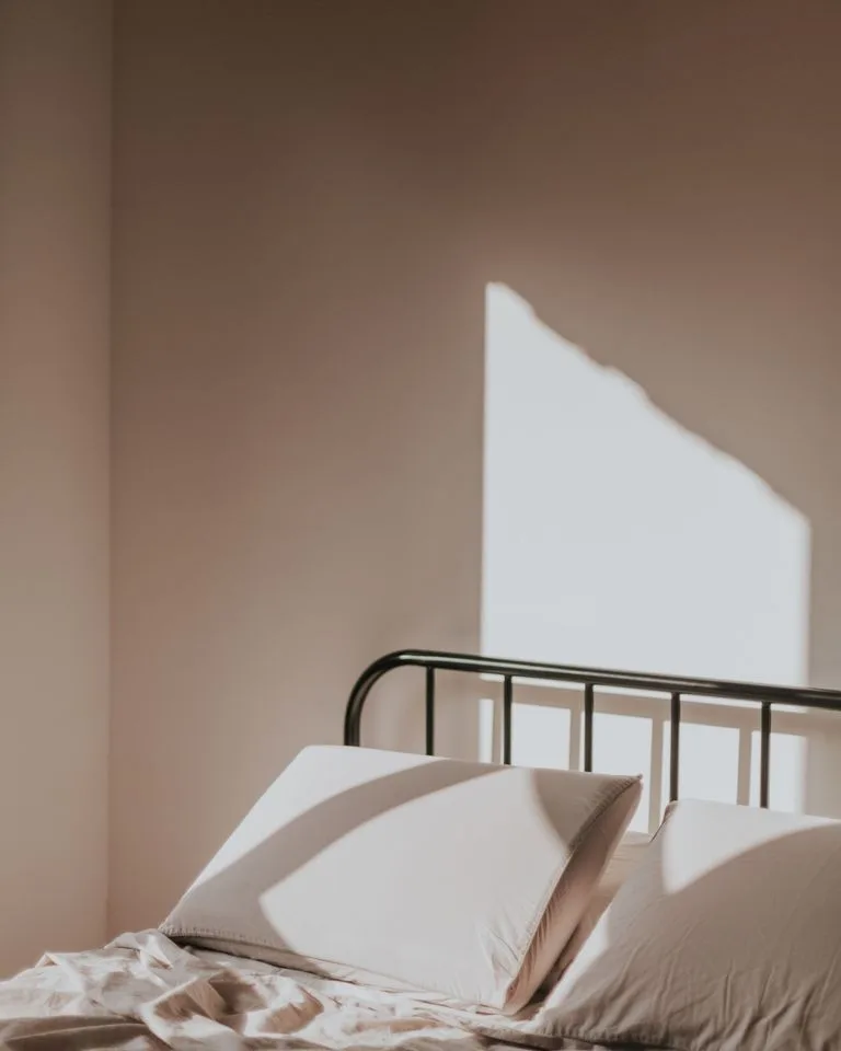 Calm beige bedroom filled with soft morning sunlight