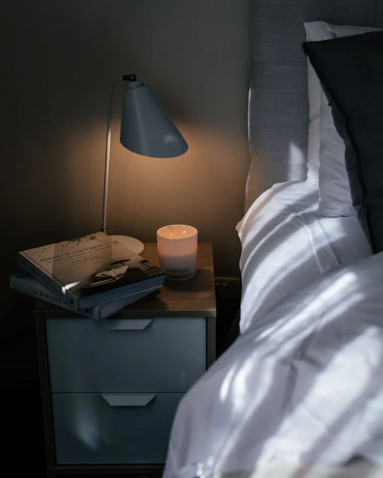 Cozy farmhouse bedroom glowing with warm bedside lamplight in the evening