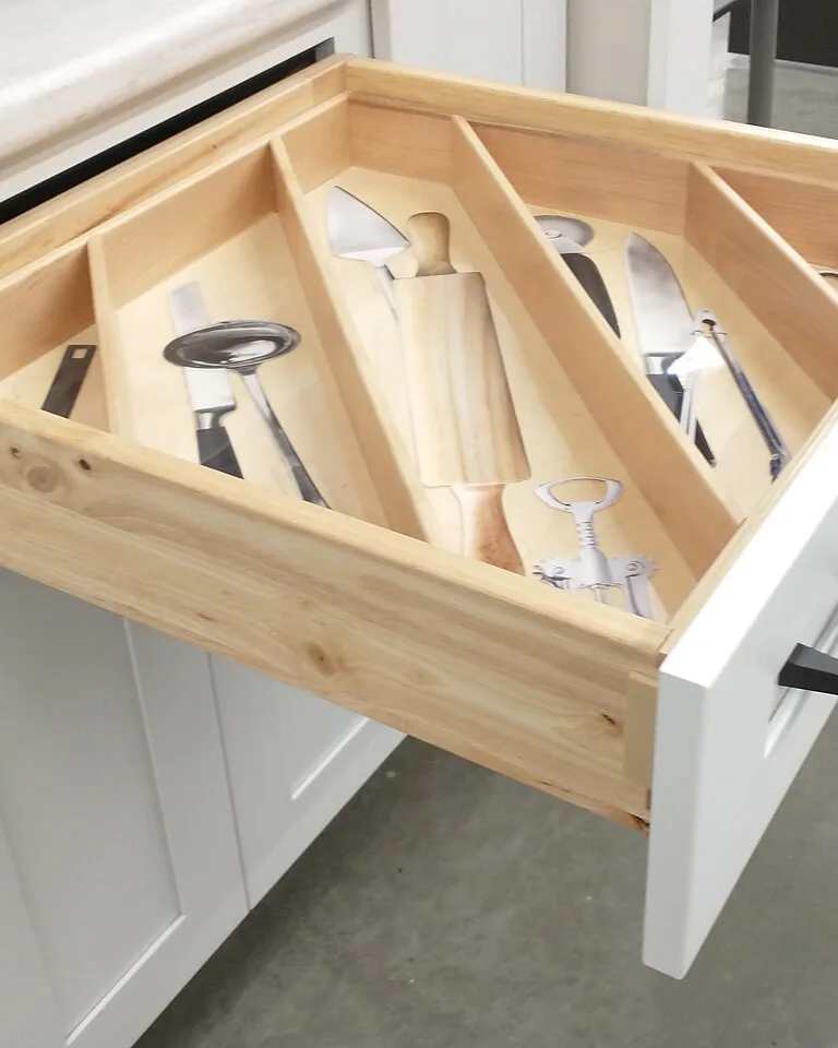 White shaker-style kitchen drawer front with a wooden cutlery organizer