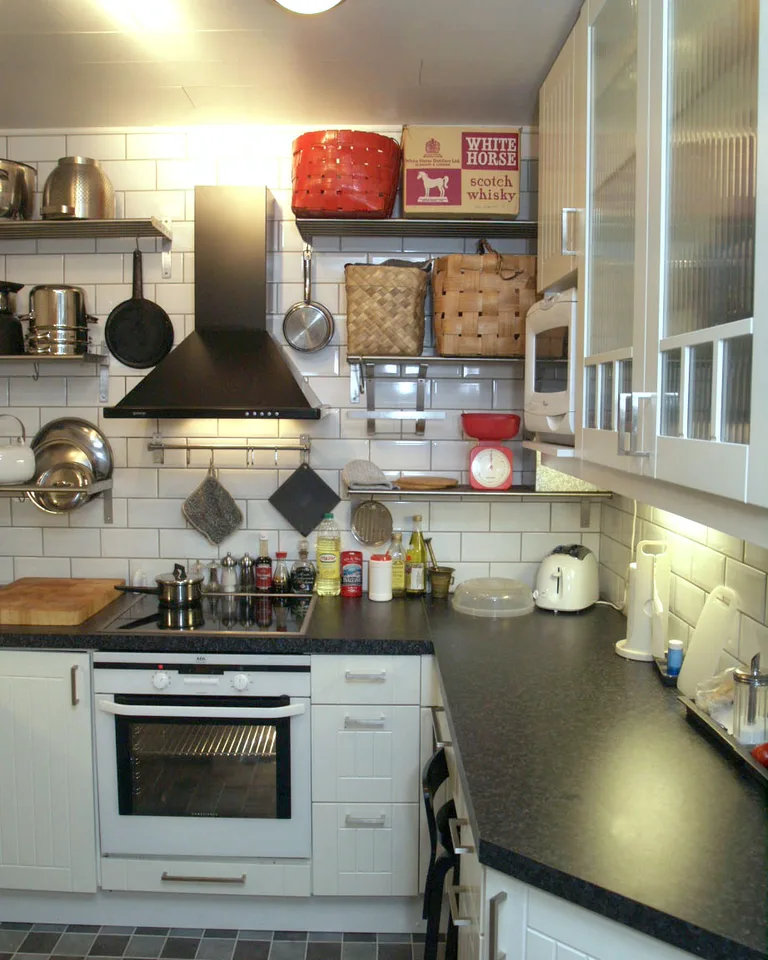 Compact black-and-white kitchen with a matte black range hood