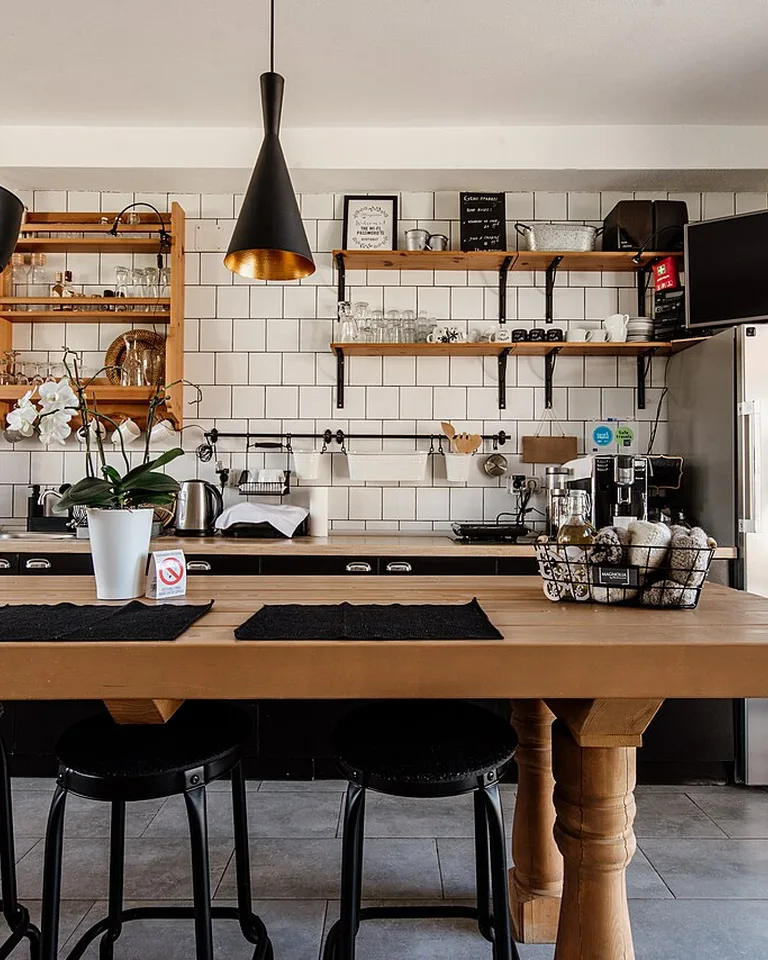 Bright kitchen with open wooden shelves styled with dishes and glassware
