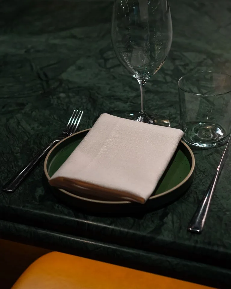 Dark green marble surface styled with a table setting