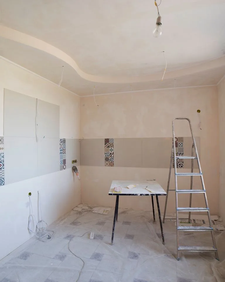 Kitchen mid-renovation with a ladder and painting supplies