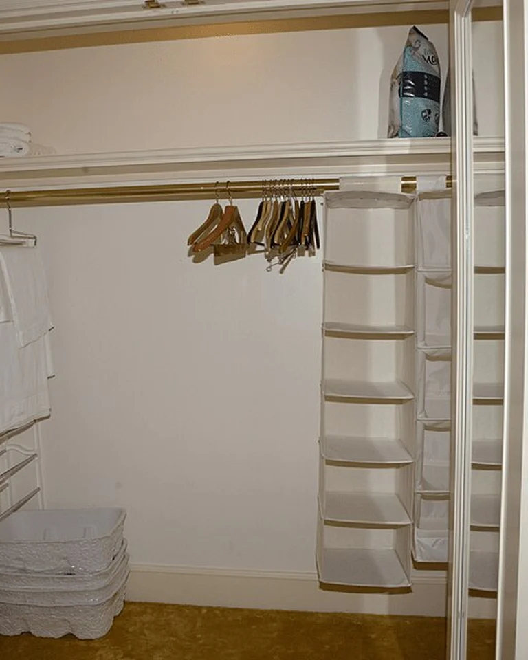 A walk-in closet with shelves, hangers, and storage baskets arranged tidily