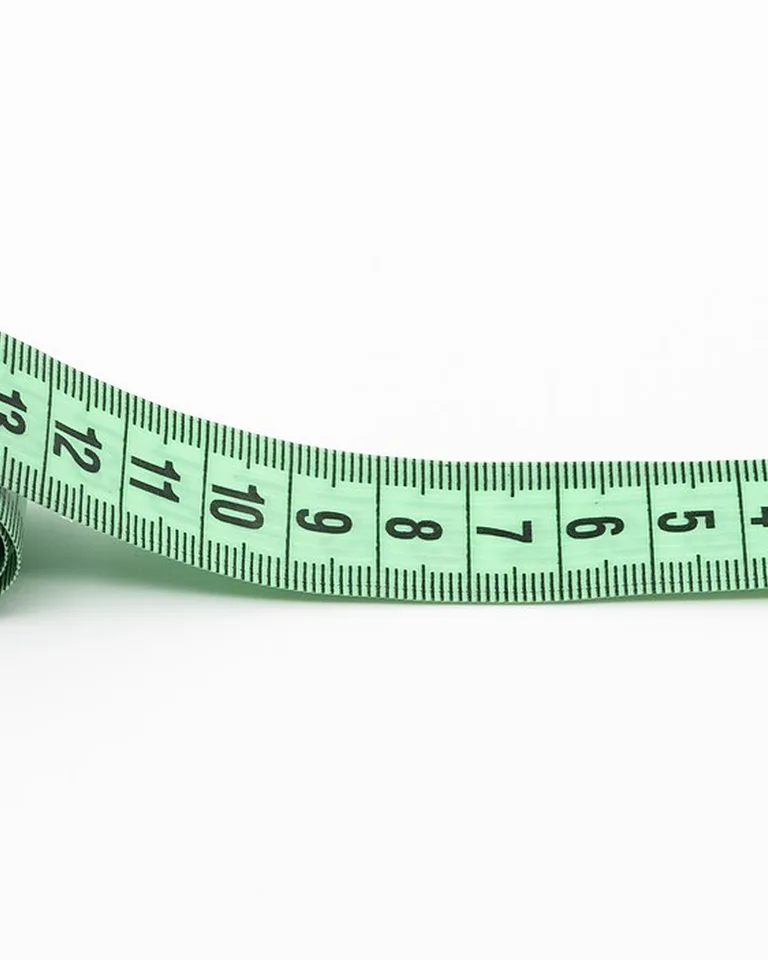 Green tailor's measuring tape on a white background