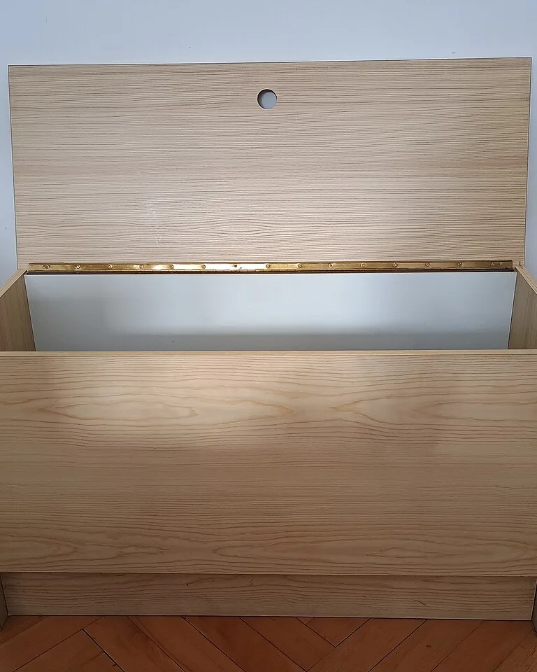 Wooden lift-top storage bench with the lid raised, revealing its deep open storage compartment