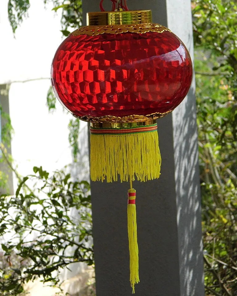 Red glass hanging lantern with a yellow tassel