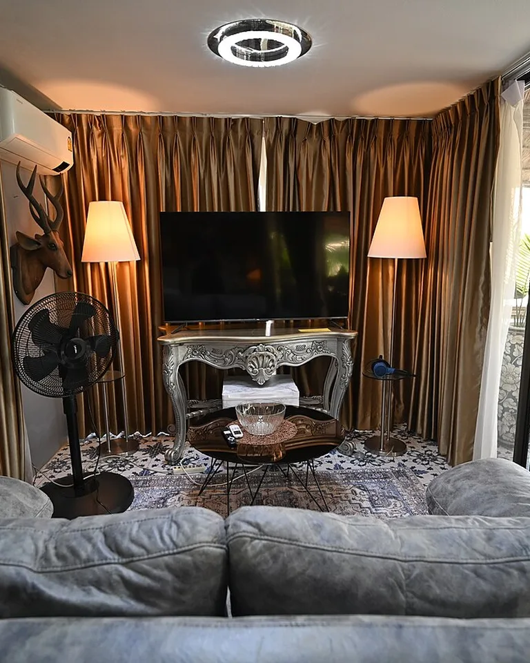 Living room with warm glowing floor lamps beside a gray sofa