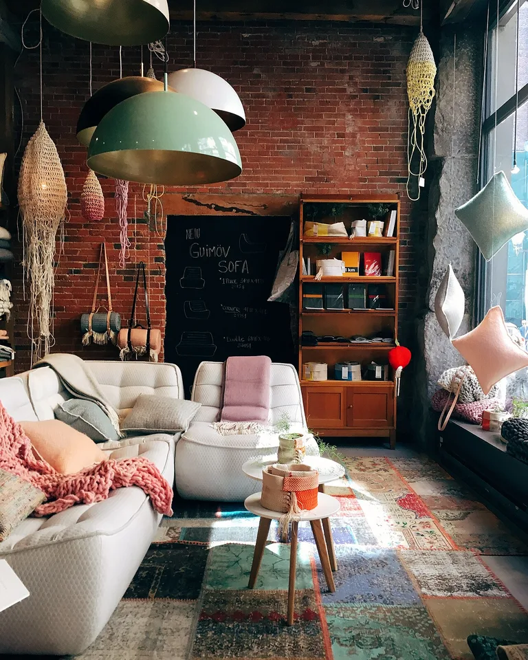 White sofas styled with cushions and a pink knit throw