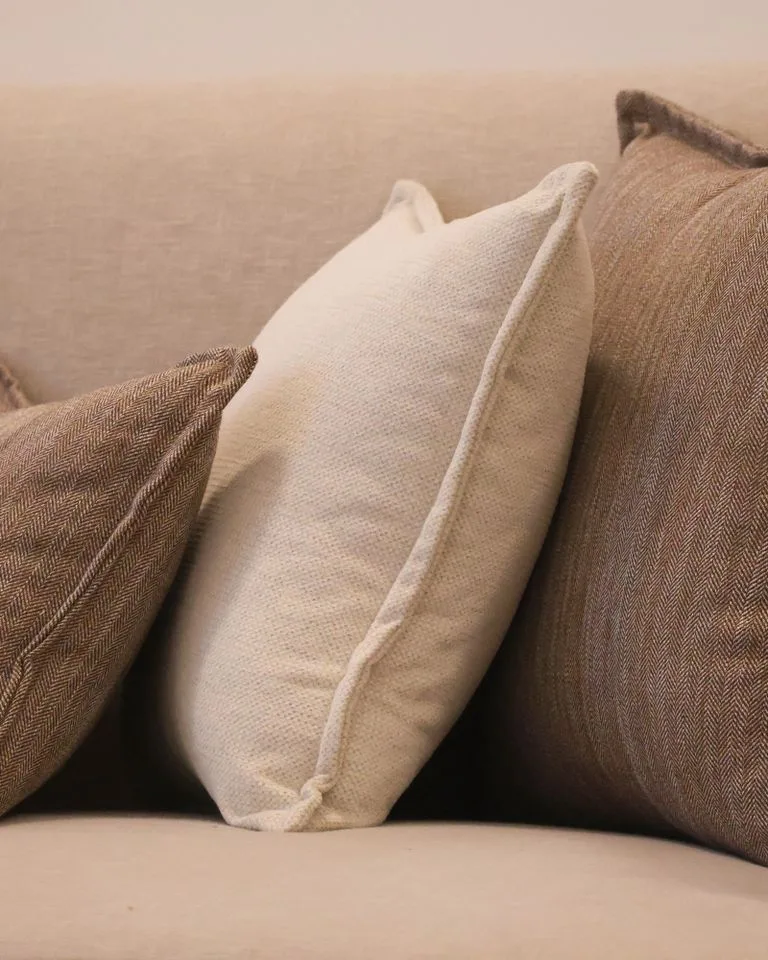 Muted neutral throw pillows arranged on a living room sofa