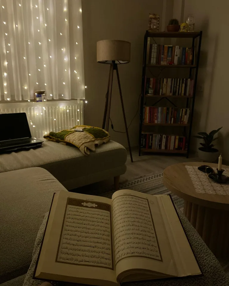 Cozy corner with fairy lights, an open book and a warm lamp