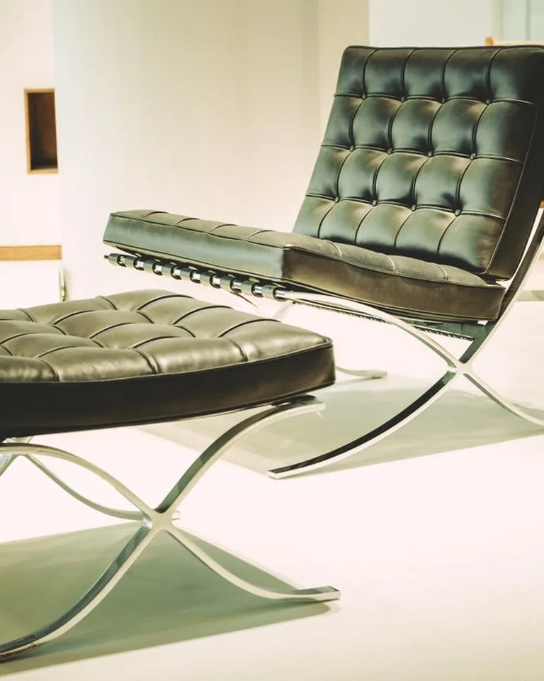 Black leather ottoman beside a matching lounge chair