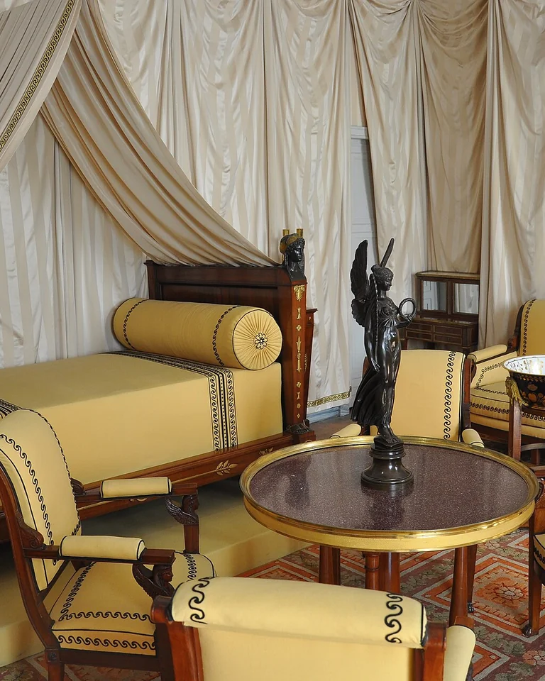 Historic bedroom with butter yellow upholstery and dark wood furniture