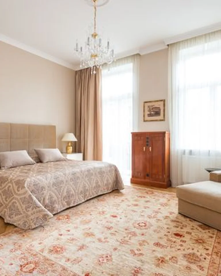 French country bedroom with a carved wood bed, white linen bedding, and soft neutral tones