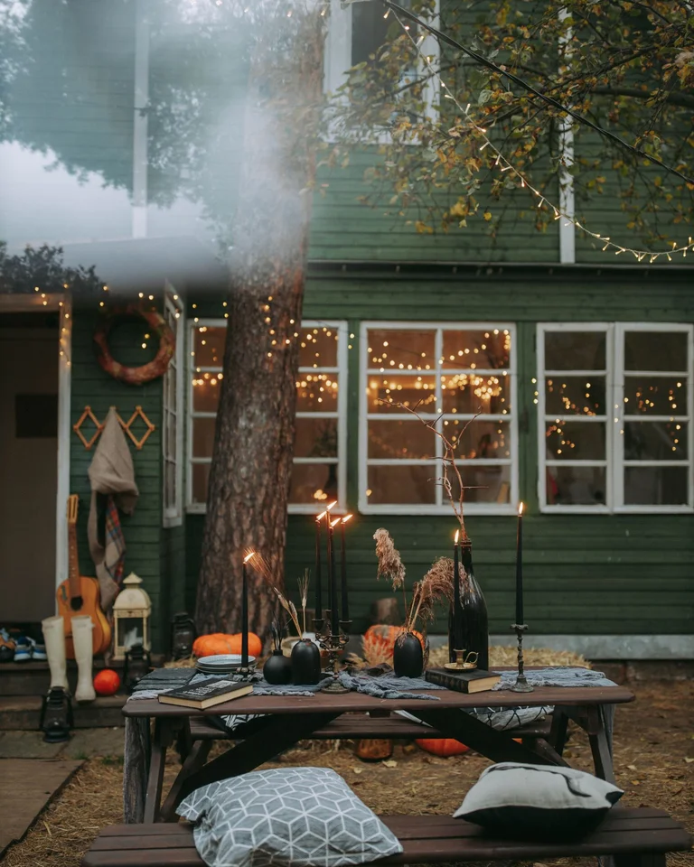 Outdoor porch decorated for Halloween with pumpkins and string lights