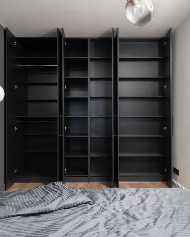 Floor-to-ceiling wardrobe cabinets maximizing vertical storage in a bedroom