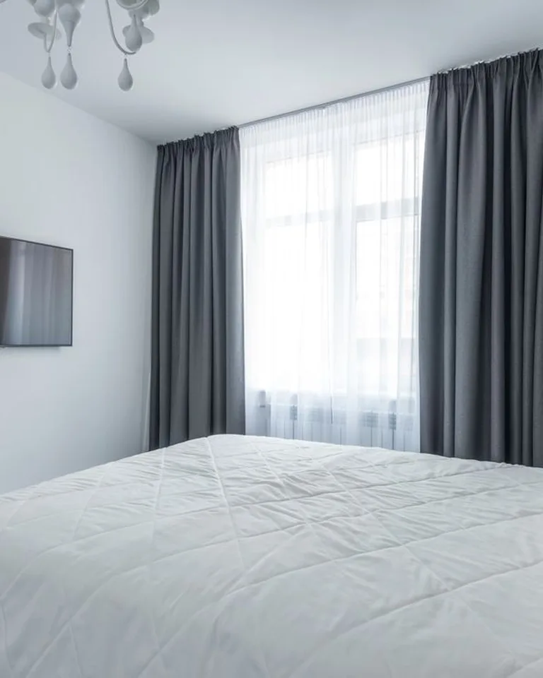 Sheer linen curtains filtering sunlight in a bedroom window