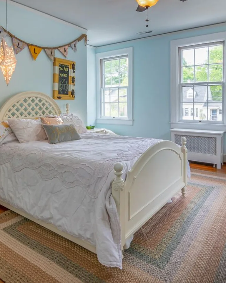 Layered jute and patterned rugs beside a bed