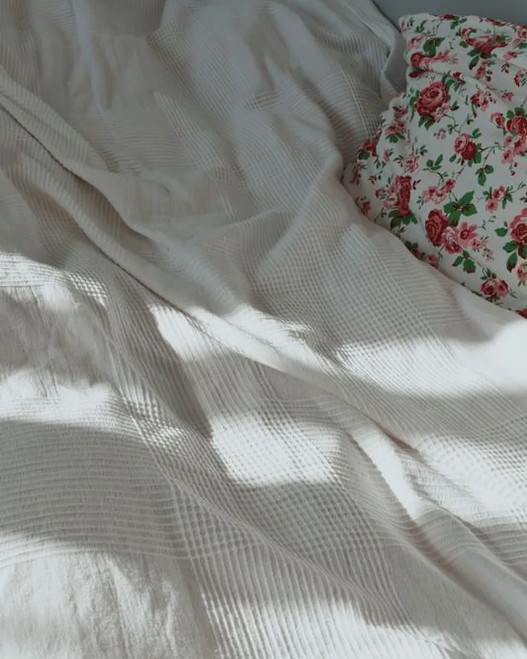 Floral patterned bedding with soft pastel tones on a bed
