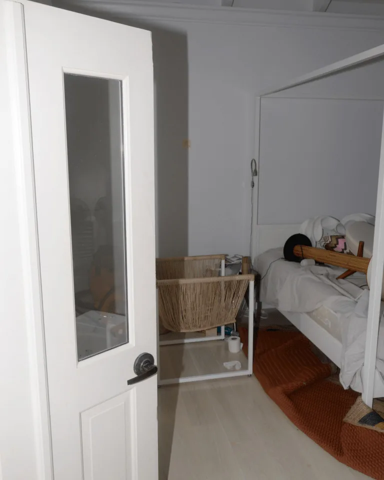 A white bedroom door with a full-length mirror mounted on its back