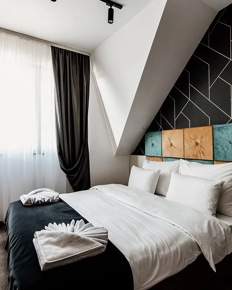 Two tall mirrors styled symmetrically on a long bedroom wall