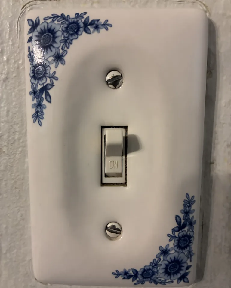 Hand turning on a modern light switch