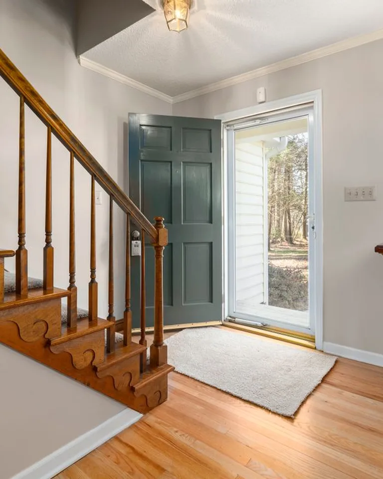 A rug placed in front of the front door creating a defined entry zone in an open floor plan