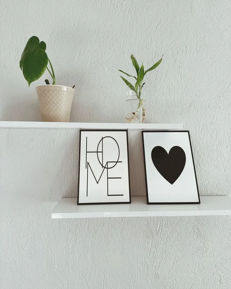 A floating wall shelf styled with small decor above an entry area