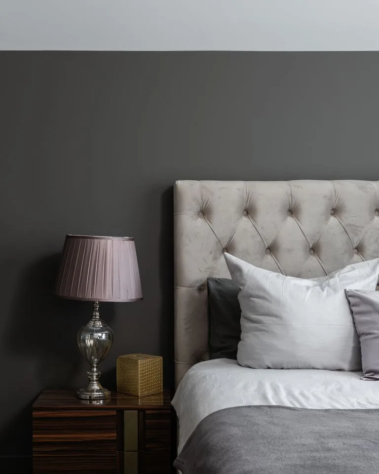 Bedroom with a deep charcoal-gray painted accent wall behind the bed