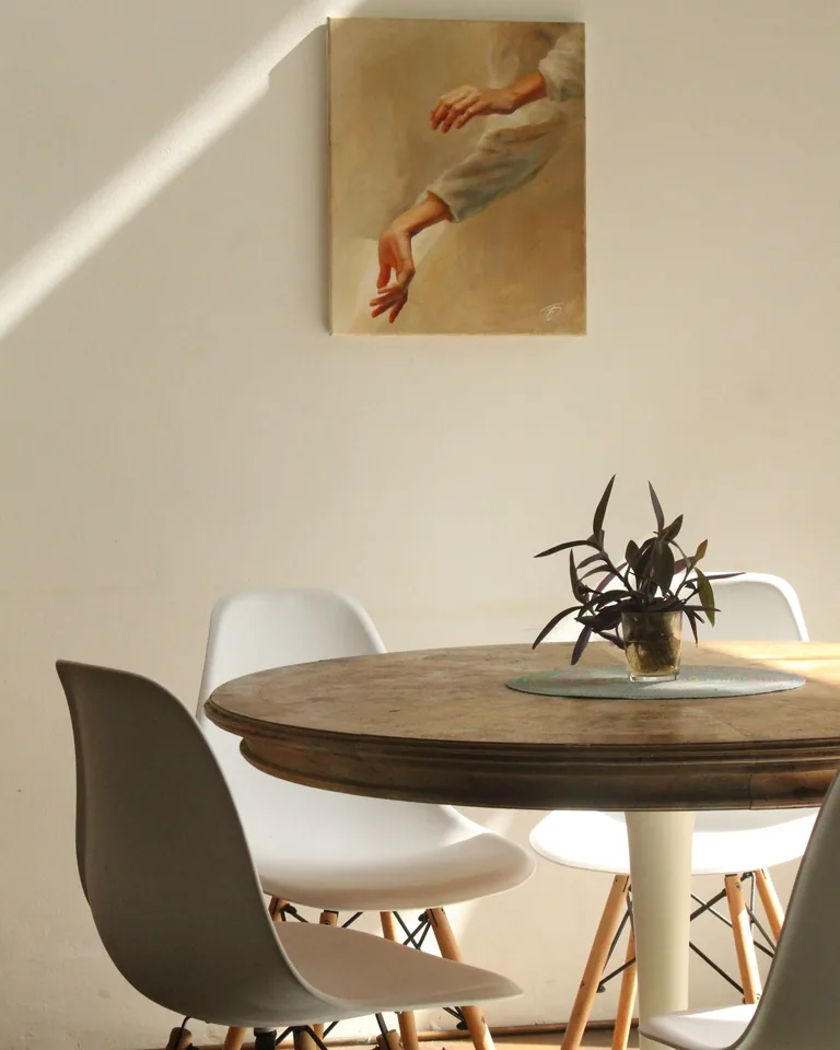 Sunlit dining room with a round wooden table and cushioned chairs