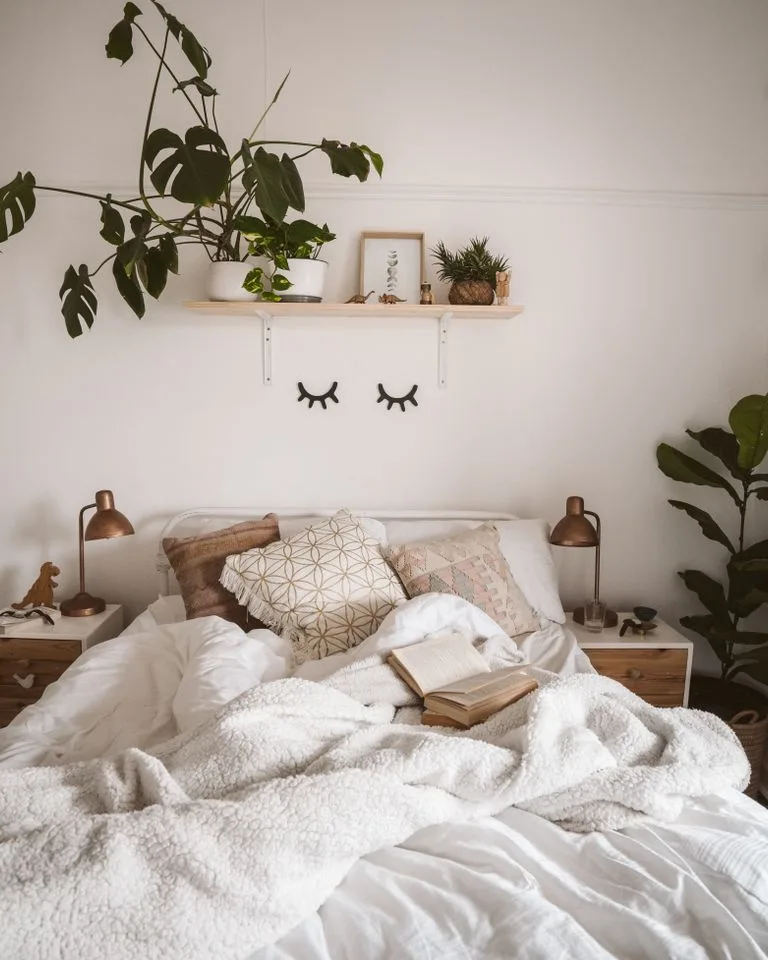 Bed dressed in crisp white linen bedding in a bright farmhouse bedroom