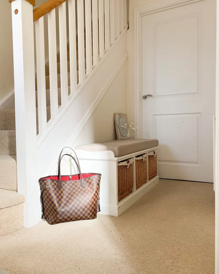 Bright entryway with a storage bench and wicker baskets underneath