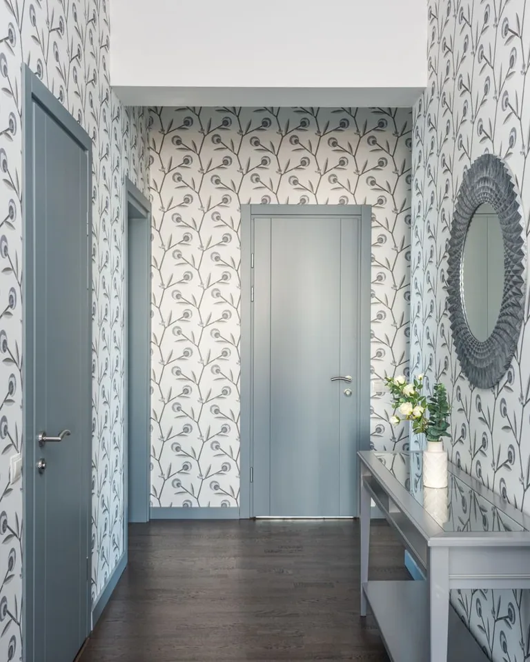 Hallway with floral wallpaper, console table and decorative accents