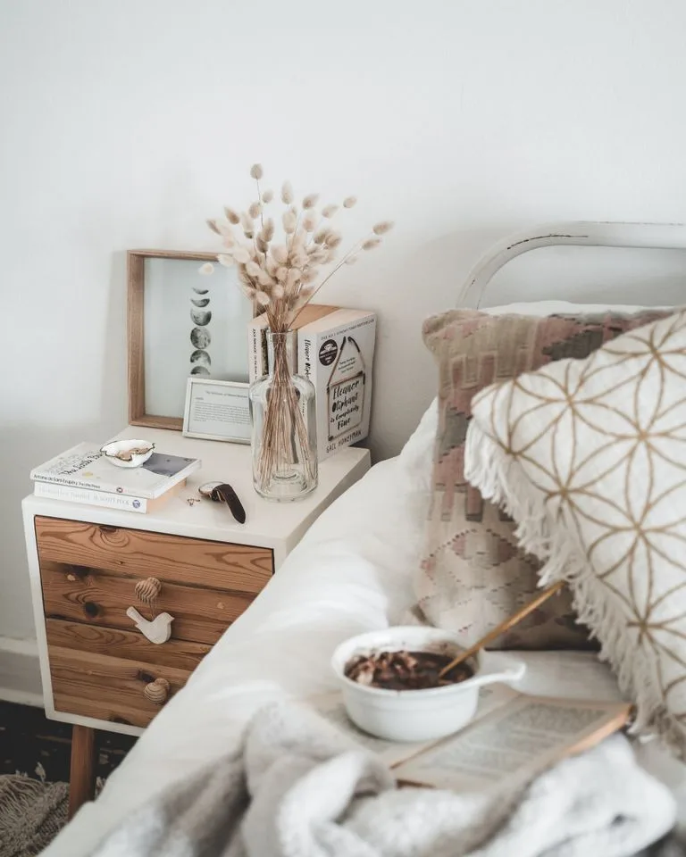 Rustic wooden nightstand styled with a lamp and books
