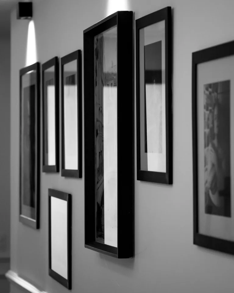 Gallery wall of framed pictures in monochrome frames