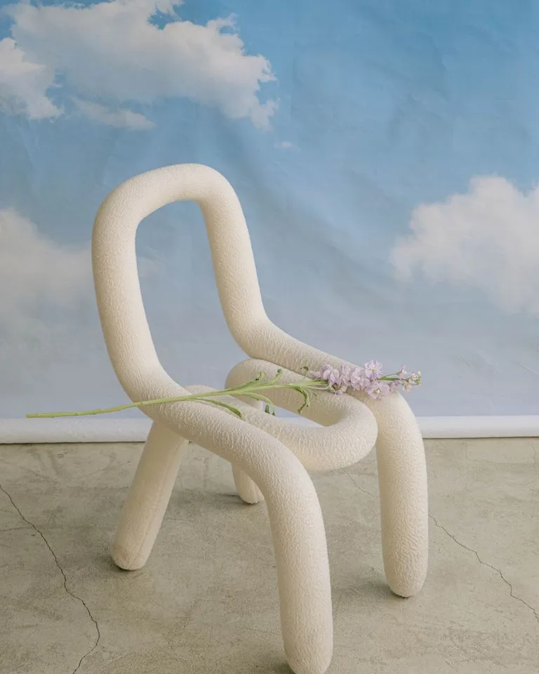 Cream bouclé accent chair in a beige bedroom corner